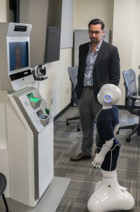 Dr. Elkins facilitates an interaction between robots Pepper and AVATAR.